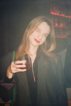 Frau im Businessanzug mit Glas in der Hand